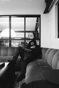 a black and white photo of a man sitting on a couch